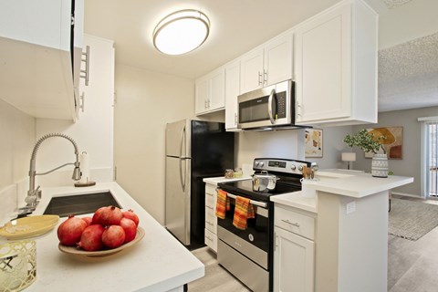 A kitchen with white cabinets and black appliances.