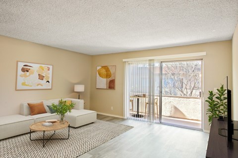 A living room with a white couch, a coffee table, and a painting on the wall.