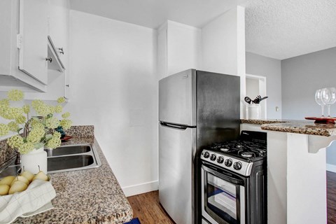 A kitchen with a black stove top oven and a white refrigerator.