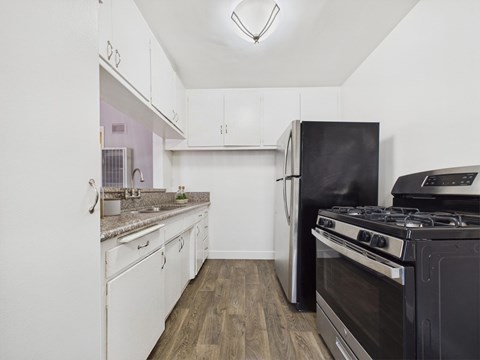 A kitchen with a black stove and white cabinets.
