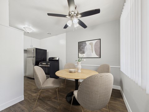 A dining room with a table and chairs.