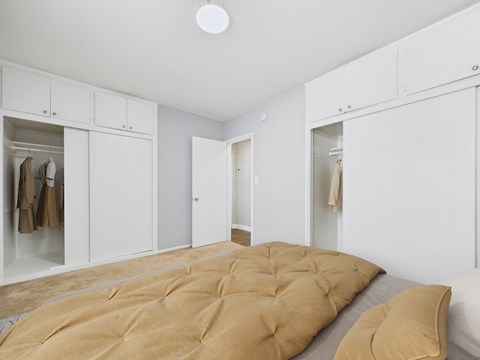 A bedroom with a bed and a wardrobe.