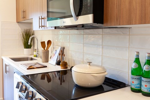 A kitchen with a black stove top and white countertop.