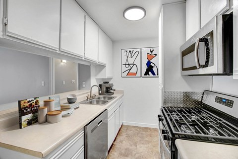 A kitchen with a stove top oven and a sink.