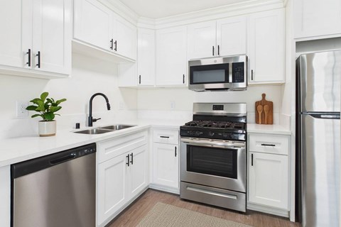 A kitchen with white cabinets and stainless steel appliances.