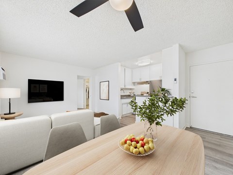 A modern living room with a wooden table and a bowl of fruit on it.