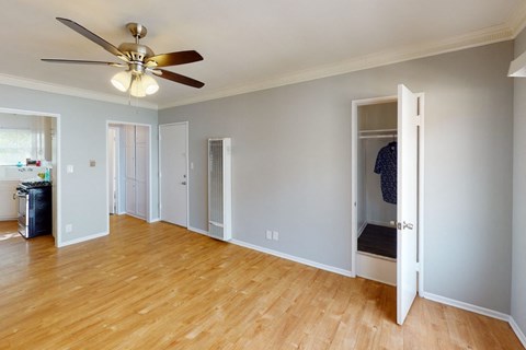 A room with a ceiling fan and wooden floors.