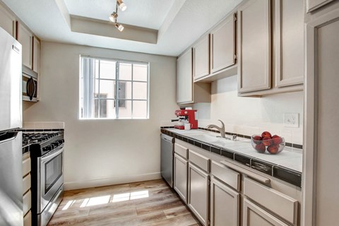 A kitchen with a stove top oven and a window.