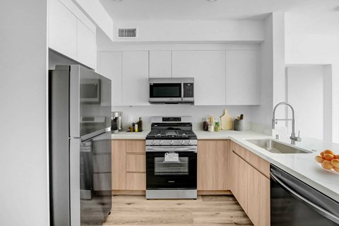 a modern kitchen with stainless steel appliances and white cabinets