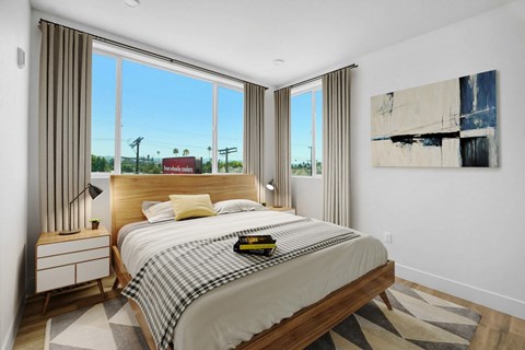 a bedroom with a bed and large windows