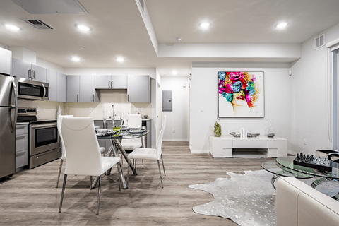 A modern kitchen with a dining table and chairs.
