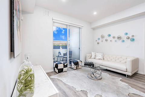 A living room with a white couch and a large window.