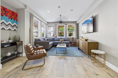 A modern living room with a brown leather chair and a grey sofa.