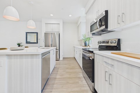 A modern kitchen with white cabinets and stainless steel appliances.