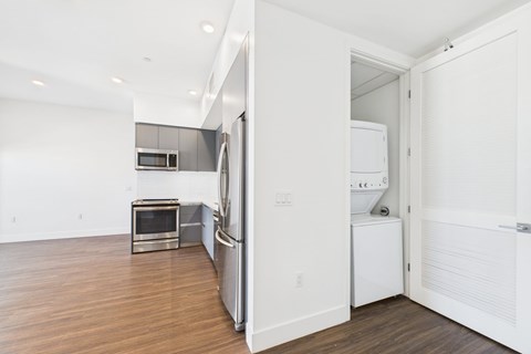 A white refrigerator is in a kitchen with a microwave and oven.