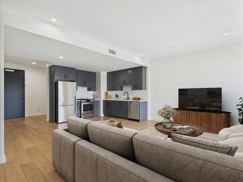 A modern living room with a grey sofa and a wooden coffee table.