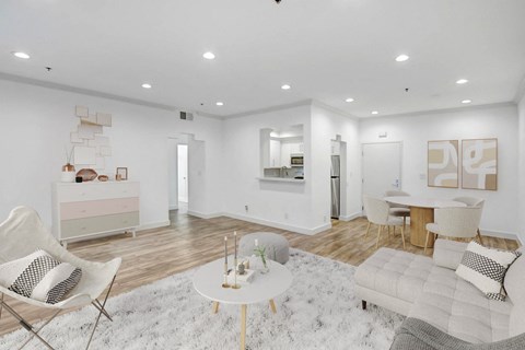 A white living room with a white rug and a white coffee table.