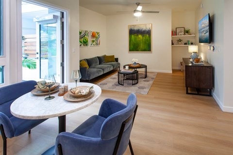 A dining room with a round table and blue chairs.