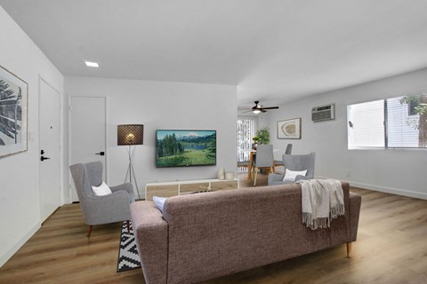 A living room with a couch, chair, and a painting on the wall.