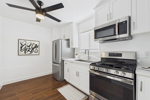 A kitchen with white cabinets and a black stove top.