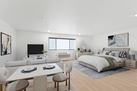 A modern bedroom with a large bed, a television, and a dining area with a table and chairs.