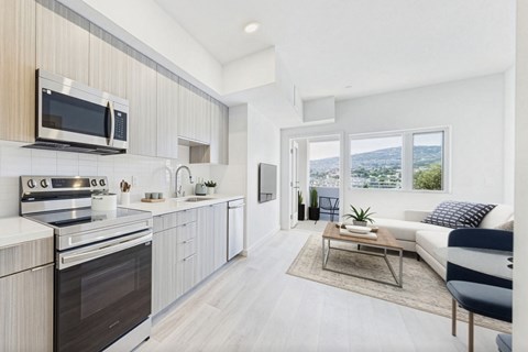 A modern kitchen with a stove top oven and microwave above it.