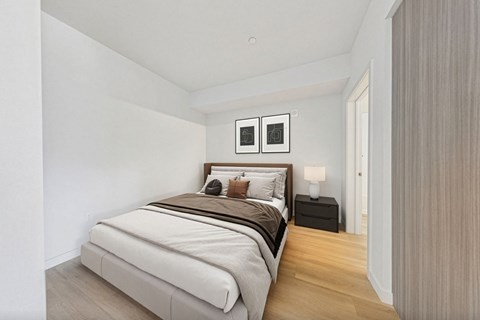 A bedroom with a large bed and two nightstands.