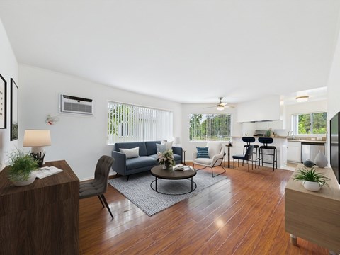 A living room with a grey couch and a wooden floor.