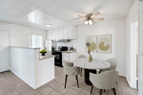 A white kitchen with a table and chairs.