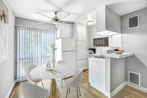 A white kitchen with a dining table and chairs.