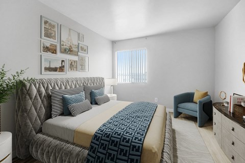 A bedroom with a large bed and a blue chair.