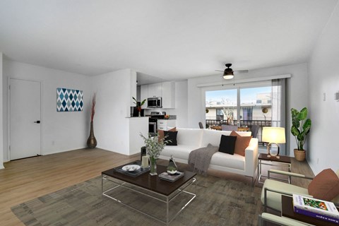 A modern living room with a glass coffee table and a white sofa.
