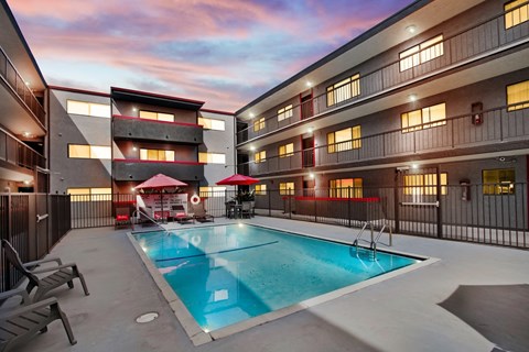 A swimming pool in a courtyard surrounded by buildings.