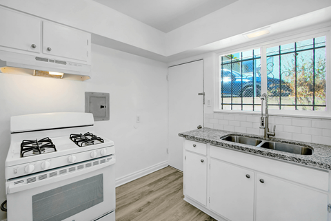 a white kitchen with a stove and a sink