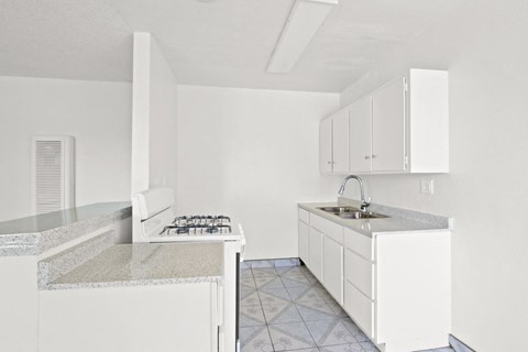 A kitchen with white cabinets and a granite countertop.