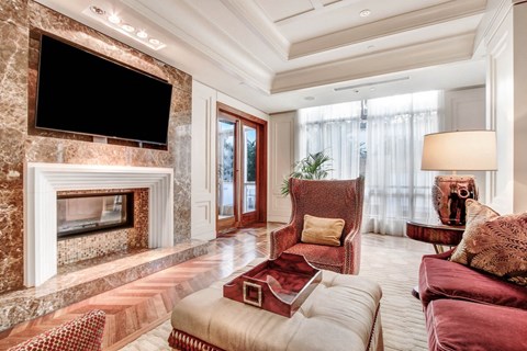 A living room with a fireplace and a television above it.