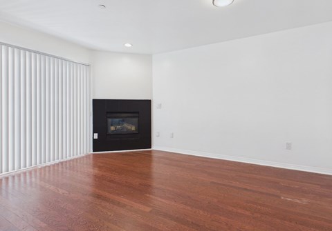 A room with a fireplace and wooden floors.