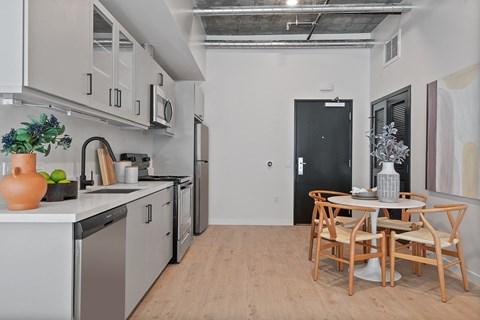 A kitchen with a table and chairs.