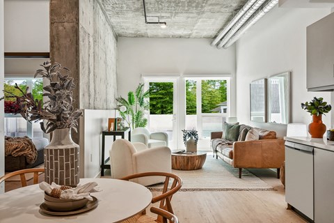 A modern living room with a dining table and chairs.