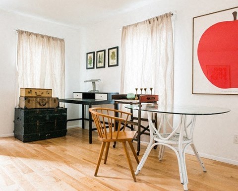 A dining room with a table and chairs.