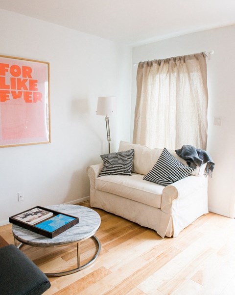 a living room with a couch and a table with a tablet on it