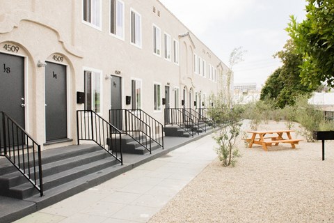 the outside of a building with a picnic table and benches