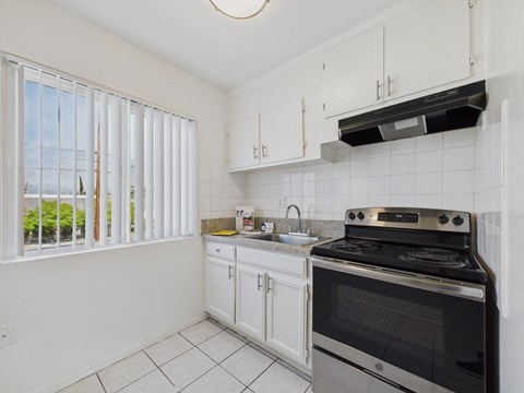 A kitchen with white cabinets and a black stove top oven.