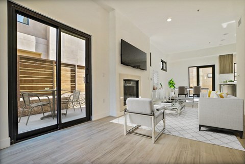 A modern living room with a white couch and a television mounted on the wall.