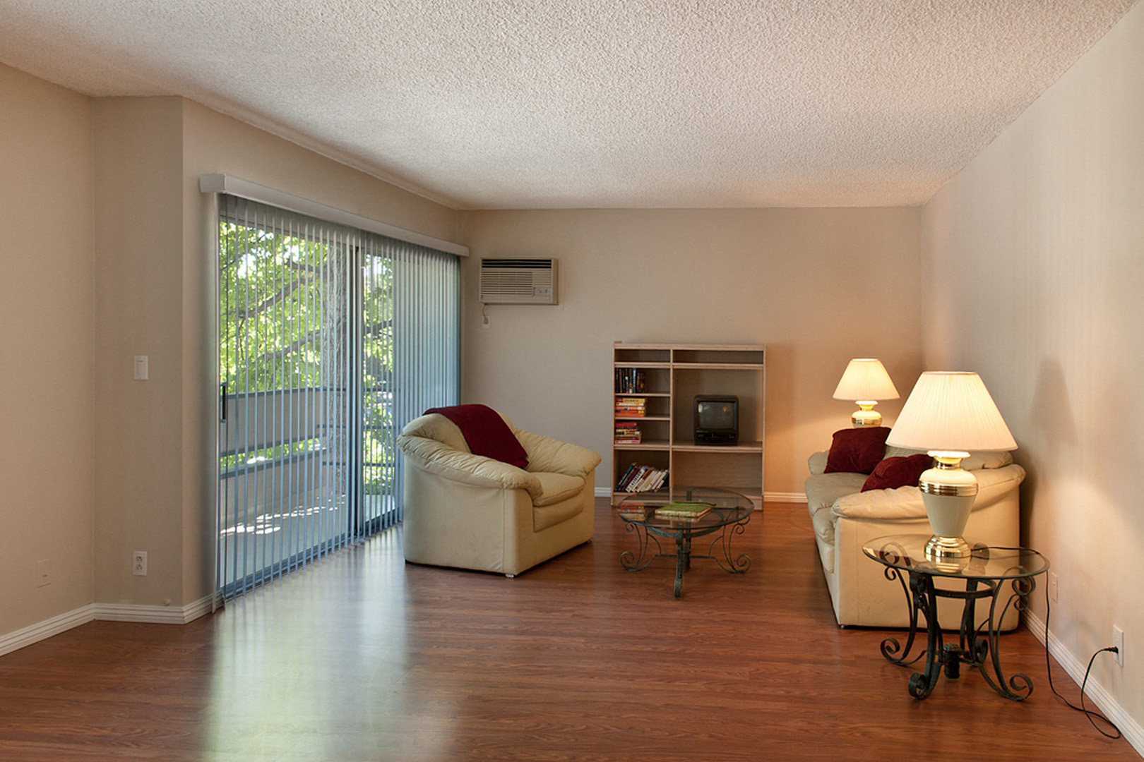 A living room with a sliding glass door and a white couch.