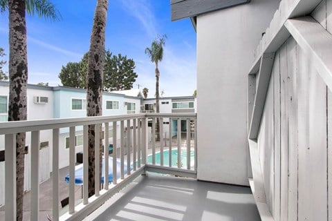 a balcony with a pool and palm trees