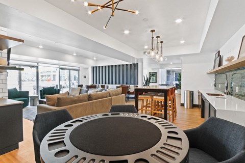 A modern living room with a large circular coffee table in the center.