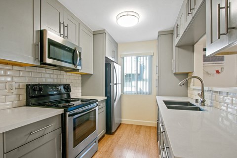 A kitchen with a black stove top oven and a black refrigerator.