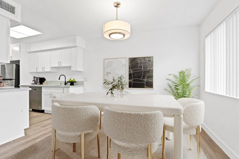 a dining room with a white table and chairs