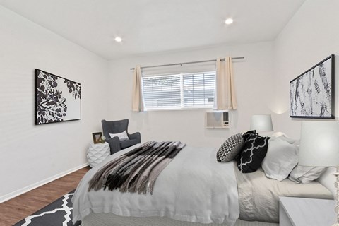 A bedroom with a large bed and two lamps.